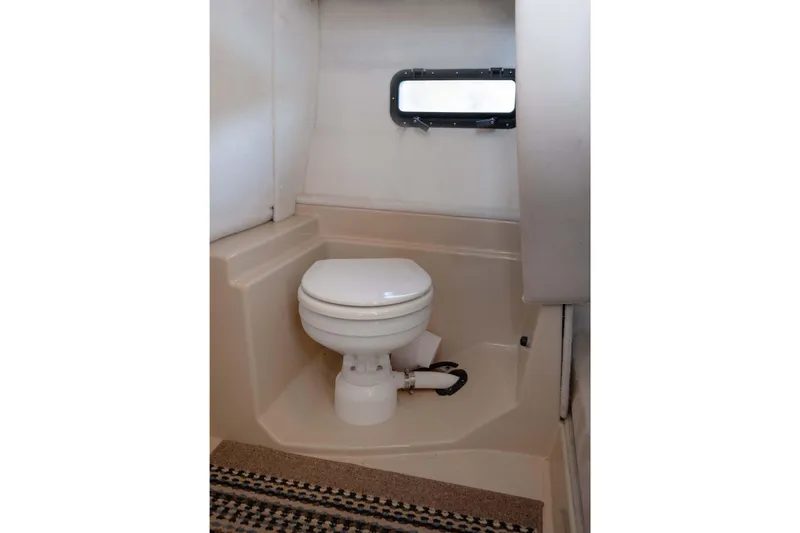 Slide: The Image of 2014 Ranger Tug R-31 CB boat bathroom with compact toilet and window. - 31