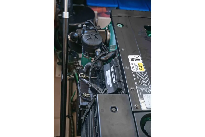 Slide: The Image of Engine compartment of 2014 Ranger Tug R-31 CB, showcasing mechanical components and caution label. - 32