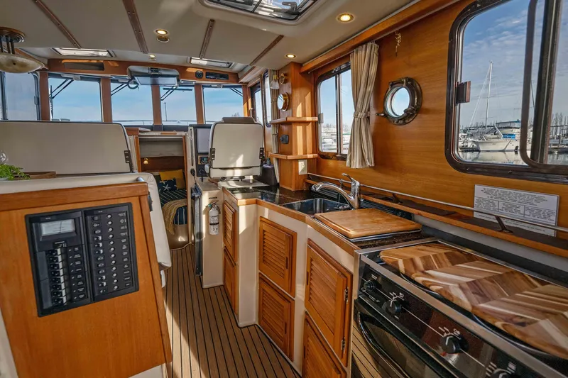 Slide: The Image of Interior of 2014 Ranger Tug R-31 CB, featuring a well-equipped kitchen and cozy cabin space. - 4