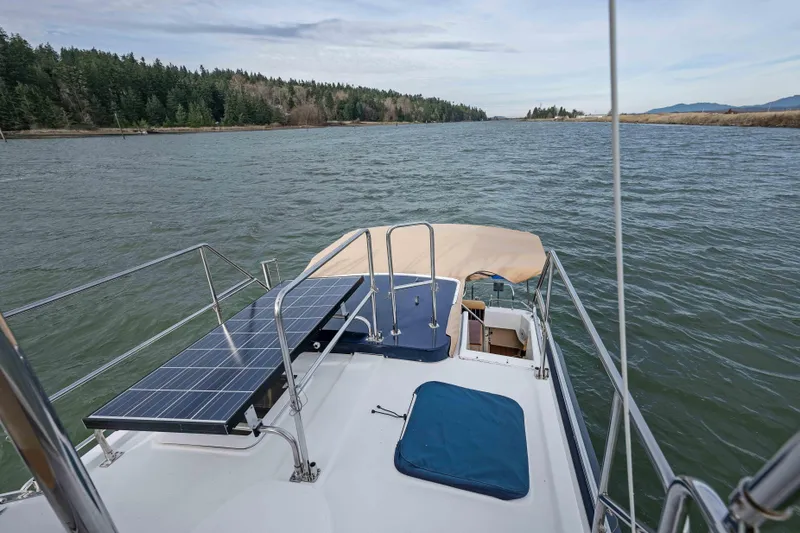 Slide: The Image of 2014 Ranger Tug R-31 CB on water, featuring solar panels and scenic river view. - 42