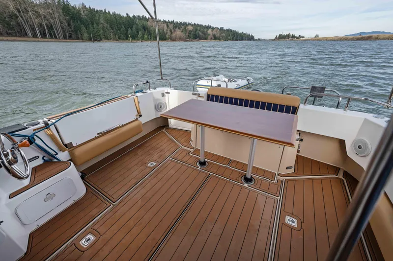 Slide: The Image of 2014 Ranger Tug R-31 CB boat deck with seating and table, on a scenic waterway. - 43