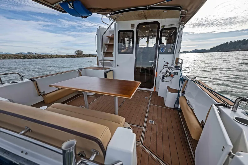 Slide: The Image of 2014 Ranger Tug R-31 CB boat interior with seating and table on open water. - 45