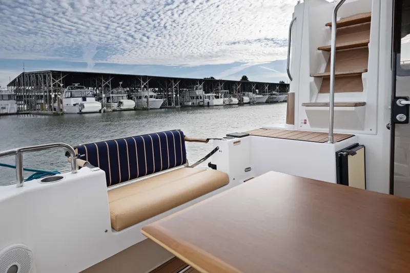 Slide: The Image of 2014 Ranger Tug R-31 CB boat interior with seating, table, and marina view. - 46