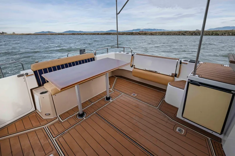 Slide: The Image of 2014 Ranger Tug R-31 CB boat deck with seating and table, overlooking water. - 47