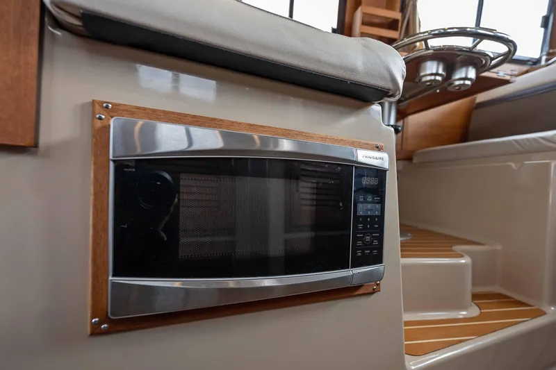 Slide: The Image of 2014 Ranger Tug R-31 CB interior with Frigidaire microwave and wooden accents. - 48