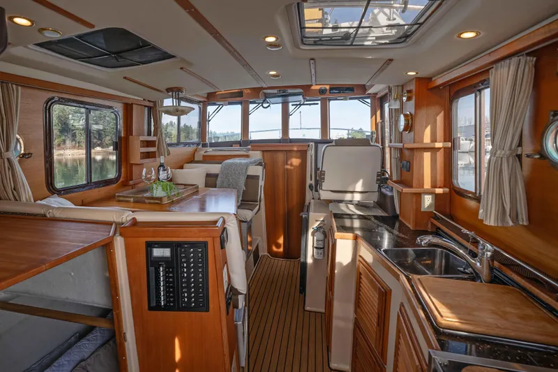 Slide: The Image of Interior of 2014 Ranger Tug R-31 CB, featuring cozy seating and modern kitchen amenities. - 5