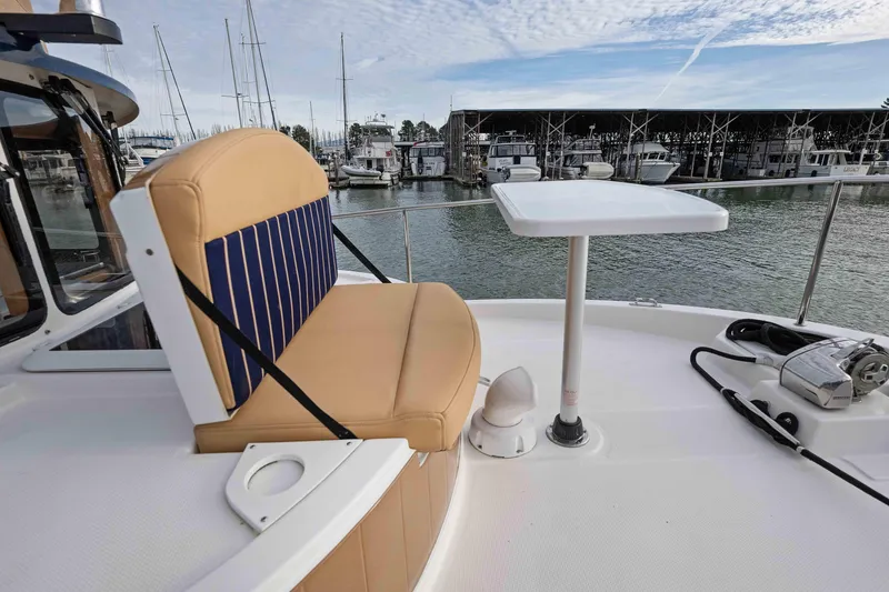 Slide: The Image of 2014 Ranger Tug R-31 CB boat deck with seating and table, marina view. - 50