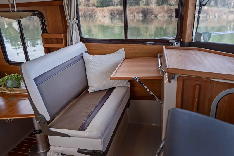 Slide: The Image of Interior of 2014 Ranger Tug R-31 CB with wooden table and cushioned seating. - 9