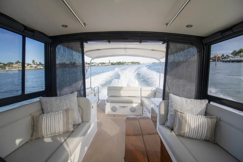 The Image of 2025 MJM 38 X boat cruising on a sunny day near luxury waterfront homes. - 0