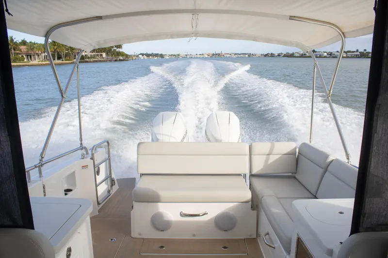 Slide: The Image of 2025 MJM 38 X boat cruising on a sunny day near luxury waterfront homes. - 1