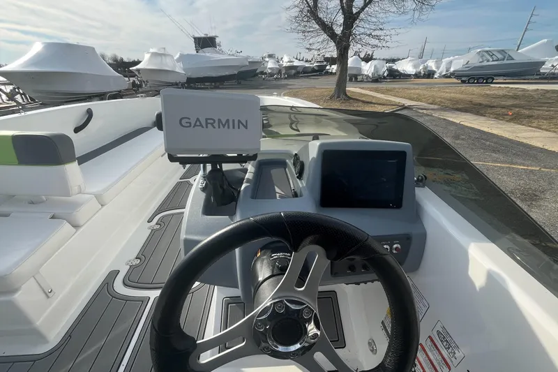 Slide: The Image of 2023 Tahoe T18 boat dashboard with Garmin navigation system, steering wheel, and seating area. - 5