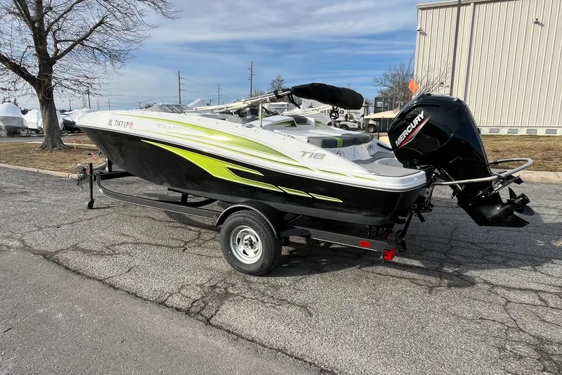 Slide: The Image of 2023 Tahoe T18 boat on trailer with Mercury outboard motor, parked outdoors. - 7