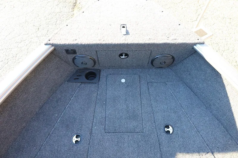 Slide: The Image of 2026 Lund 1775 Impact XS Sport boat interior with carpeted deck and storage compartments. - 17