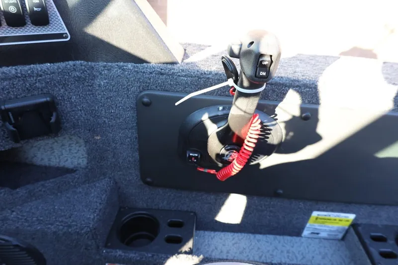 Slide: The Image of 2026 Lund 1775 Impact XS Sport boat control panel with throttle lever and cup holder. - 30