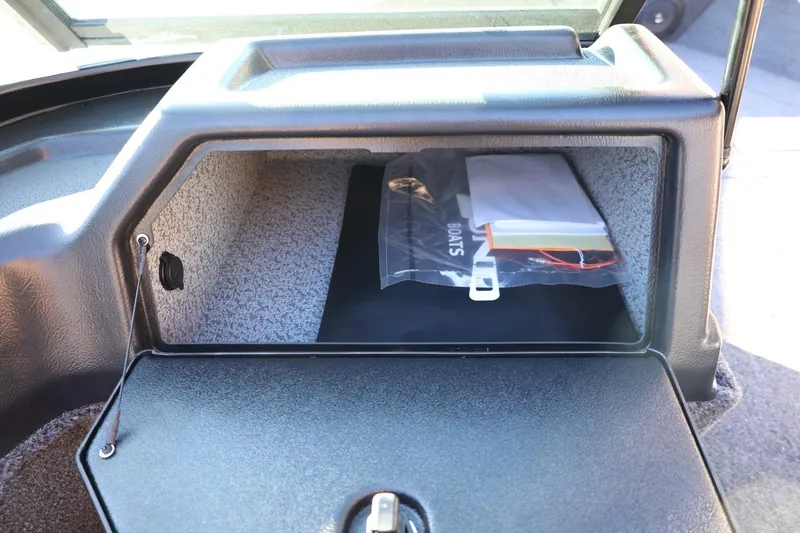 Slide: The Image of 2026 Lund 1775 Impact XS Sport boat storage compartment with documents inside. - 32