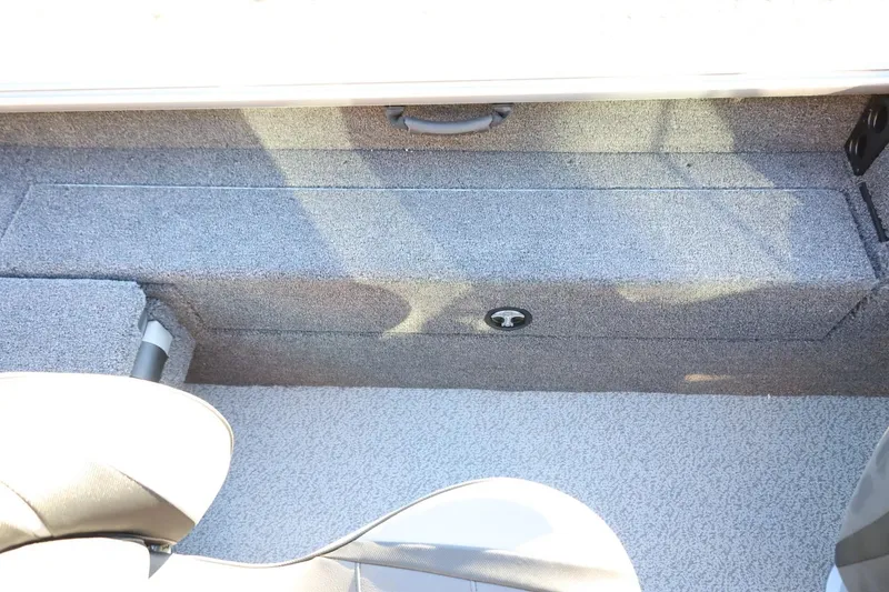 Slide: The Image of Interior view of 2026 Lund 1775 Impact XS Sport boat, featuring carpeted storage area. - 35