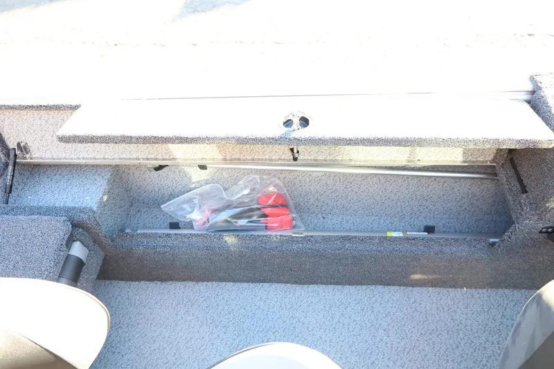 Slide: The Image of 2026 Lund 1775 Impact XS Sport boat storage compartment with tools and accessories. - 36