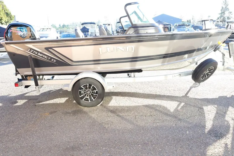 Slide: The Image of 2026 Lund 1775 Impact XS Sport boat on trailer, parked outdoors in sunlight. - 5