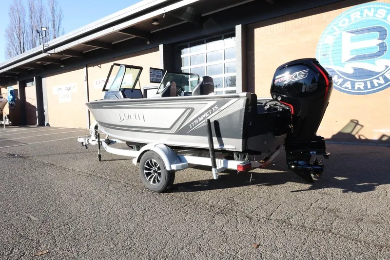 Slide: The Image of 2026 Lund 1775 Impact XS Sport boat on trailer outside marine dealership. - 8