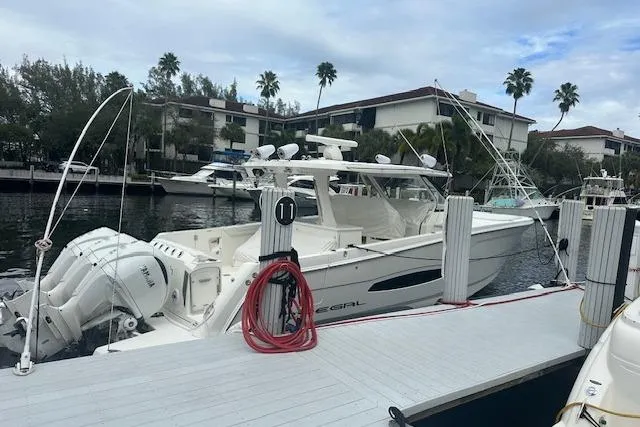 The Image of 2022 Regal 38 SAV boat docked at marina with palm trees in background. - 0