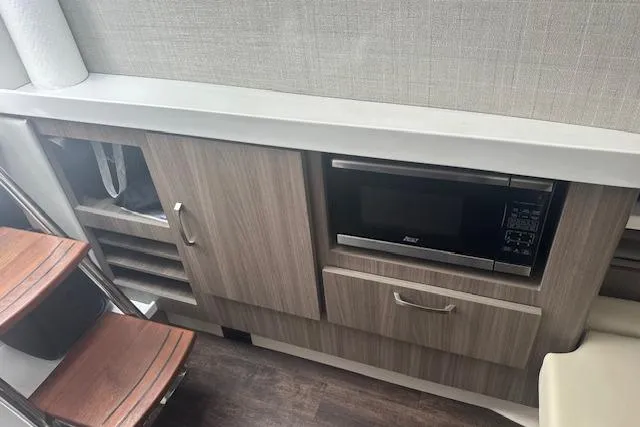 Slide: The Image of Modern kitchen area in 2022 Regal 38 SAV boat with microwave and wooden cabinetry. - 15