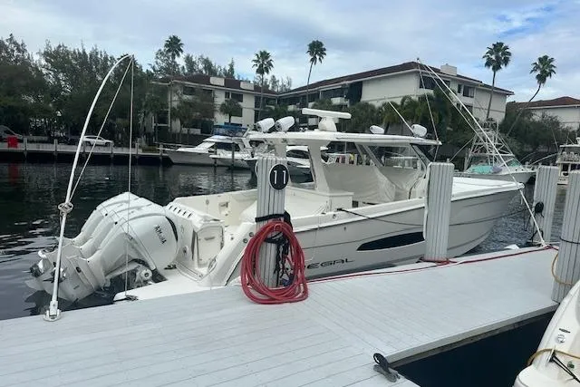 Slide: The Image of 2022 Regal 38 SAV boat docked at a marina with twin outboard engines. - 39