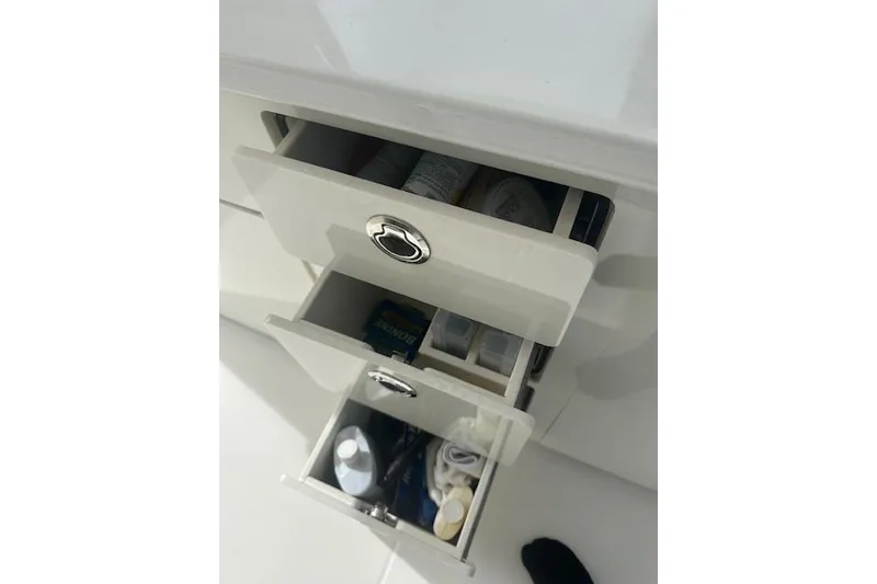 Slide: The Image of Open drawers on a 2022 Regal 38 SAV boat, containing various items. - 45