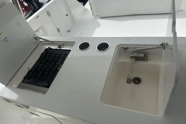 Slide: The Image of 2022 Regal 38 SAV boat kitchen area with grill and sink. - 48