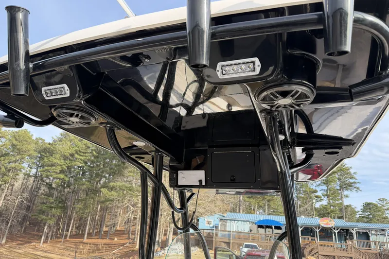 Slide: The Image of 2024 Sea Born SX239 Offshore boat's T-top with speakers and lights, dockside view. - 14