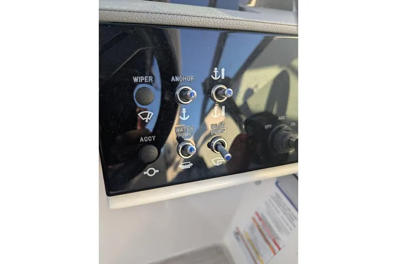 Slide: The Image of Control panel of 2021 Sea Ray SDX 270 Outboard with switches for wiper, anchor, and pumps. - 22