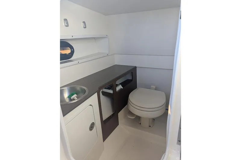 Slide: The Image of 2021 Sea Ray SDX 270 Outboard boat interior bathroom with sink and toilet. - 26
