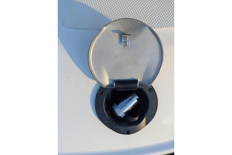 Slide: The Image of Fuel cap of 2021 Sea Ray SDX 270 Outboard boat, open with metal fitting inside. - 28