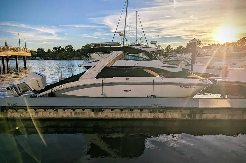 Slide: The Image of 2021 Sea Ray SDX 270 Outboard docked at sunset, reflecting on calm water. - 3