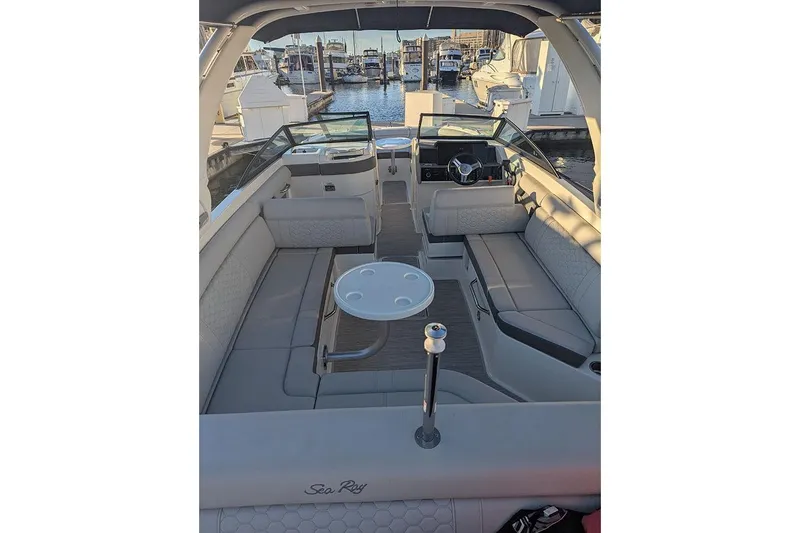 Slide: The Image of 2021 Sea Ray SDX 270 Outboard boat interior with seating and table, docked at marina. - 35