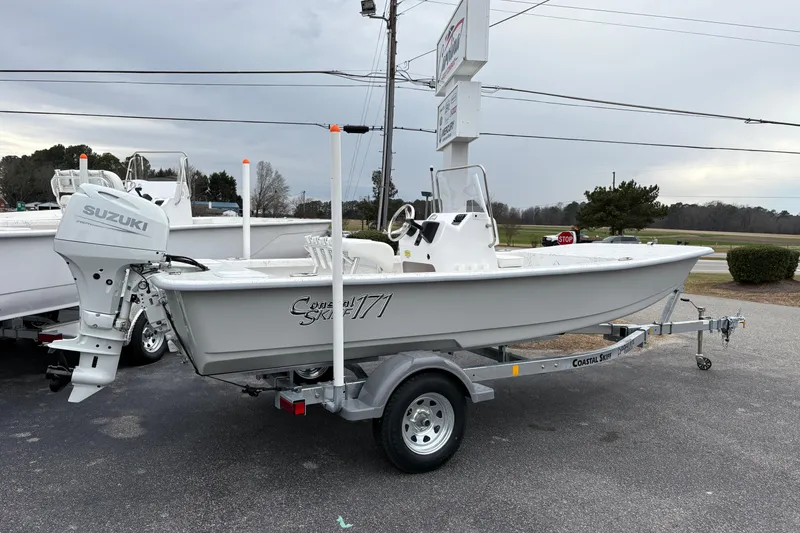 The Image of 2026 Coastal Skiff 171 boat on trailer with Suzuki outboard motor, parked outdoors. - 1