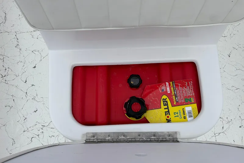 Slide: The Image of Open storage compartment in 2026 Coastal Skiff 171 with red fuel tank inside. - 10