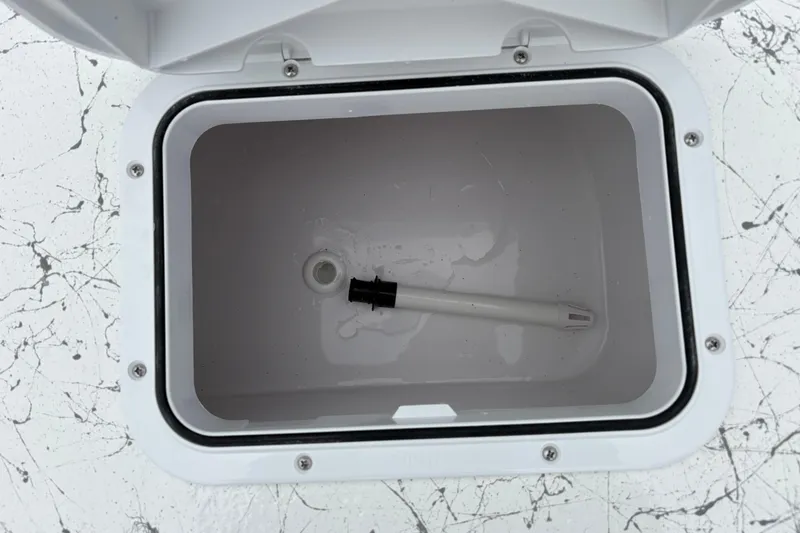 Slide: The Image of Open storage compartment in 2026 Coastal Skiff 171 boat, featuring a white interior. - 12