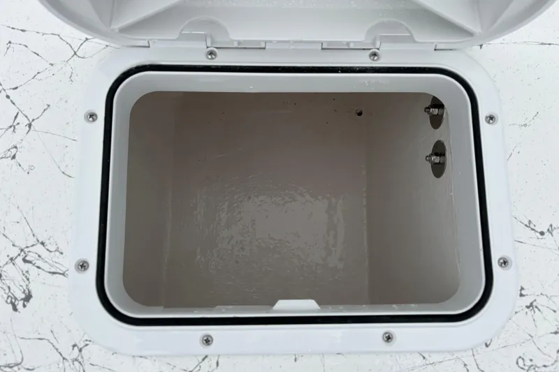 Slide: The Image of Open storage compartment on 2026 Coastal Skiff 171 boat, featuring a clean, white interior. - 13