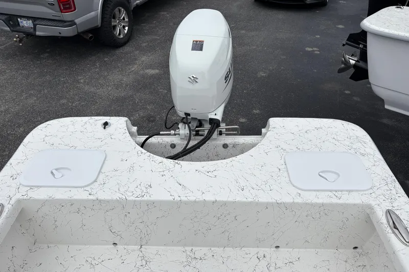 Slide: The Image of 2026 Coastal Skiff 171 boat with Suzuki outboard motor, parked on asphalt. - 14