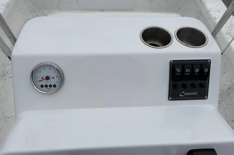 Slide: The Image of 2026 Coastal Skiff 171 dashboard with gauge, cup holders, and control panel. - 16