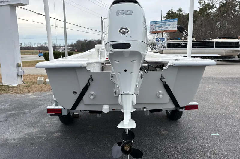 Slide: The Image of 2026 Coastal Skiff 171 boat with outboard motor, displayed on a trailer in a dealership. - 7