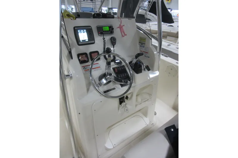 Slide: The Image of 2011 Pursuit C 230 Center Console boat dashboard with steering wheel and navigation controls. - 14