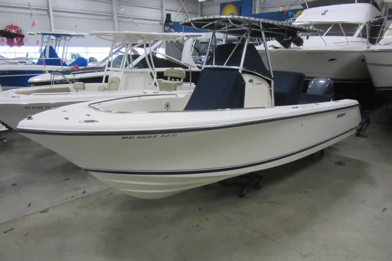 Slide: The Image of 2011 Pursuit C 230 Center Console boat in showroom, side view. - 2