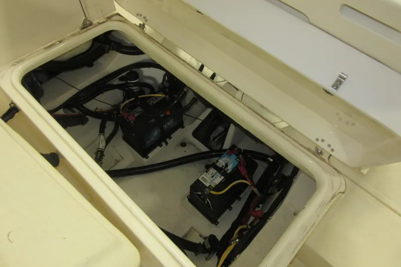 Slide: The Image of 2011 Pursuit C 230 Center Console boat battery compartment with wiring and components. - 22