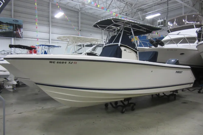 Slide: The Image of 2011 Pursuit C 230 Center Console boat displayed indoors, showcasing sleek design. - 32