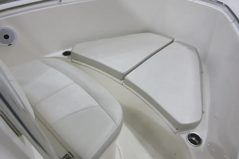 Slide: The Image of 2011 Pursuit C 230 Center Console boat interior seating area with white cushions. - 6