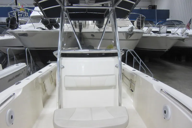 Slide: The Image of 2011 Pursuit C 230 Center Console boat in showroom, surrounded by other vessels. - 8
