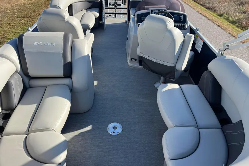 Slide: The Image of 2022 Sylvan Mirage X1 Tritoon interior with luxurious seating and modern helm. - 2