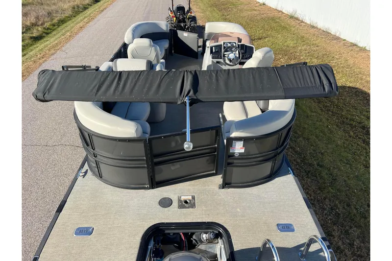 Slide: The Image of 2022 Sylvan Mirage X1 Tritoon boat with seating and steering console on a road. - 37