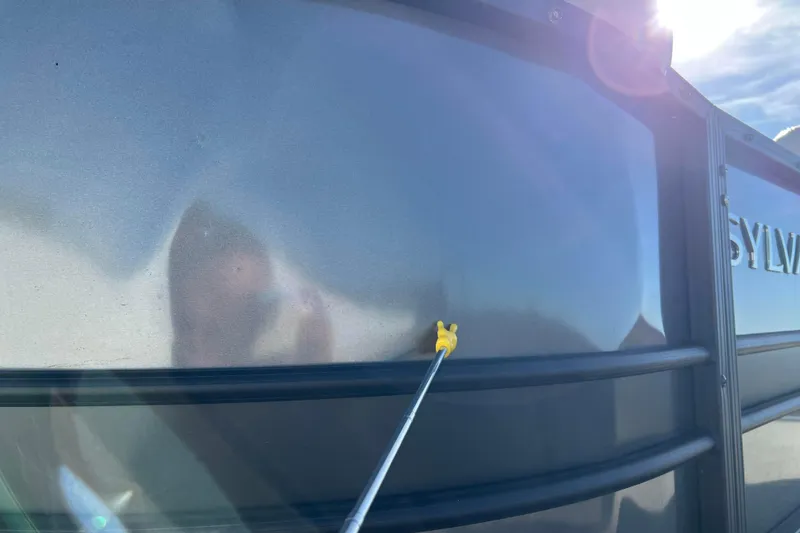 Slide: The Image of 2022 Sylvan Mirage X1 Tritoon exterior with reflection and sunlight glare. - 39